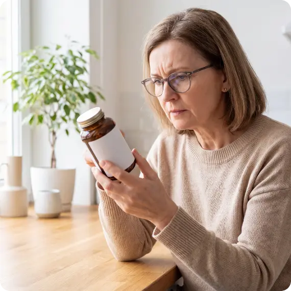 Frau liest das Etikett eines Nahrungsergänzungsmittels